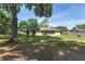View of the spacious backyard featuring mature trees providing ample shade at 1601 Ne 47Th Ct, Ocala, FL 34470