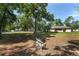 Large, fenced backyard with mature trees and an outdoor seating area at 1601 Ne 47Th Ct, Ocala, FL 34470