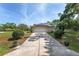 View of the home featuring a long driveway leading to an attached garage with solar panels at 1601 Ne 47Th Ct, Ocala, FL 34470