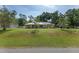 Well-maintained home exterior with a metal roof, solar panels, a green lawn, and mature landscaping on a spacious lot at 1601 Ne 47Th Ct, Ocala, FL 34470