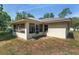 Back exterior view of a home with a screened in porch and a well manicured backyard at 1601 Ne 47Th Ct, Ocala, FL 34470