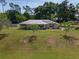 Well-kept home with solar panels, metal roof, a large lawn, and mature trees on a sunny day at 1601 Ne 47Th Ct, Ocala, FL 34470