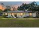 Charming single-story home featuring a metal roof, solar panels, rocking chairs on the porch, and a lush green lawn at 1601 Ne 47Th Ct, Ocala, FL 34470