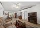 Open-concept living area boasts wood-look floors, a ceiling fan, and a decorative display shelf at 1601 Ne 47Th Ct, Ocala, FL 34470
