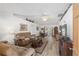 Bright living room with vaulted ceiling, wood-look floors, neutral paint, and comfortable seating for relaxation at 1601 Ne 47Th Ct, Ocala, FL 34470
