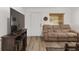 Cozy living room featuring wood-look floors, comfortable sofa, and a large TV for entertainment at 1601 Ne 47Th Ct, Ocala, FL 34470