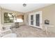A well-lit screened porch with wicker furniture, a fire pit, and tile flooring at 1601 Ne 47Th Ct, Ocala, FL 34470