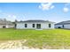 Backyard view showcases a grassy lawn, the home's exterior, and sliding glass doors at 16697 Sw 30 Avenue Rd, Ocala, FL 34473