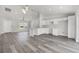 Open-concept kitchen and living area with white cabinets and gray wood floors for seamless living at 16697 Sw 30 Avenue Rd, Ocala, FL 34473