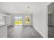 Bright, open-concept living room with stylish gray wood floors and natural light from a sliding glass door at 16697 Sw 30 Avenue Rd, Ocala, FL 34473