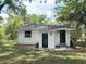 Back of a white home with dark blue doors, black fence, and trees at 1705 Nw 18Th Ave, Ocala, FL 34475