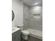 Bathroom featuring a tiled shower, white toilet, grey vanity, and grey vinyl floors at 1705 Nw 18Th Ave, Ocala, FL 34475