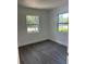 Bedroom showcasing updated grey vinyl floors, two windows, and white walls at 1705 Nw 18Th Ave, Ocala, FL 34475