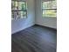 Bedroom showcasing updated grey vinyl floors, two windows, and white walls at 1705 Nw 18Th Ave, Ocala, FL 34475