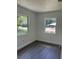 Bedroom featuring updated grey vinyl floors, two windows, and white walls at 1705 Nw 18Th Ave, Ocala, FL 34475