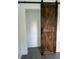 Stained barn door and closet with black hardware and updated grey vinyl floors at 1705 Nw 18Th Ave, Ocala, FL 34475