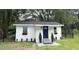 Cute white home with a dark blue door, flower boxes, landscaped bushes and a black fence at 1705 Nw 18Th Ave, Ocala, FL 34475