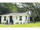 Charming white home with a dark blue front door, small front yard, black fence and mature trees at 1705 Nw 18Th Ave, Ocala, FL 34475