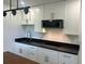 Modern white kitchen with black granite countertops, kitchen island, and stainless steel faucet at 1705 Nw 18Th Ave, Ocala, FL 34475