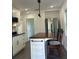 Modern white kitchen with a kitchen island and stainless steel refrigerator at 1705 Nw 18Th Ave, Ocala, FL 34475