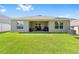Well-maintained backyard with a covered patio, surrounded by lush green grass, ideal for outdoor living and activities at 181 Nw 45Th Loop, Ocala, FL 34475