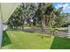 Expansive backyard with a wooden fence, green grass, and mature trees providing a serene and private outdoor space at 181 Nw 45Th Loop, Ocala, FL 34475