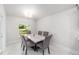 Bright dining room featuring an elegant marble table, six chairs, modern lighting and wood look tile flooring at 181 Nw 45Th Loop, Ocala, FL 34475