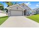 Well-maintained single-story home with a spacious driveway, garage, and manicured lawn at 181 Nw 45Th Loop, Ocala, FL 34475