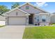 Inviting single-story home with a tidy front lawn, neutral color palette, and attached garage at 181 Nw 45Th Loop, Ocala, FL 34475