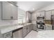 Modern kitchen with gray cabinets, stainless steel appliances, and granite countertops at 181 Nw 45Th Loop, Ocala, FL 34475
