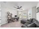 Bright living room area with a comfortable gray sofa, desk, and bay window at 181 Nw 45Th Loop, Ocala, FL 34475