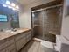 Bathroom featuring a large mirror, vanity with drawers, a shower with glass doors, and a toilet at 1910 Sw 34Th Ct, Ocala, FL 34474