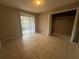Bedroom featuring neutral walls, tile floors, closet with sliding doors, and natural light at 1910 Sw 34Th Ct, Ocala, FL 34474
