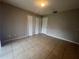 Empty bedroom with tile flooring, a double door closet, neutral walls, and a white door at 1910 Sw 34Th Ct, Ocala, FL 34474