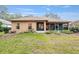 View of the back exterior of home with screened in patio and landscaped yard at 19586 Sw 84Th Pl, Dunnellon, FL 34432