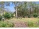 Lush backyard oasis featuring mature trees and a charming seating area, creating a serene outdoor retreat at 19586 Sw 84Th Pl, Dunnellon, FL 34432