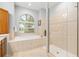 Bathroom with a large soaking tub, a separate shower, and a large window at 19586 Sw 84Th Pl, Dunnellon, FL 34432