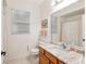 Bright bathroom featuring a vanity with marble countertop and a large mirror at 19586 Sw 84Th Pl, Dunnellon, FL 34432