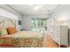 Bedroom with neutral walls, a ceiling fan, dresser, and access to a screened-in porch at 19586 Sw 84Th Pl, Dunnellon, FL 34432