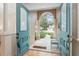 Inviting entryway boasts a covered porch with pillars and decorative blue doors at 19586 Sw 84Th Pl, Dunnellon, FL 34432