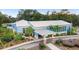 Beautiful community building featuring a covered entrance and lush, meticulously maintained landscaping at 19586 Sw 84Th Pl, Dunnellon, FL 34432