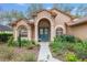 Inviting home exterior with a decorative blue double door and manicured front garden at 19586 Sw 84Th Pl, Dunnellon, FL 34432