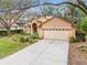 Attractive home showcasing a lush lawn, mature landscaping, and a welcoming driveway, exuding curb appeal at 19586 Sw 84Th Pl, Dunnellon, FL 34432