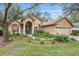 Charming single-story home with a lush landscaped front yard and inviting arched entryway at 19586 Sw 84Th Pl, Dunnellon, FL 34432