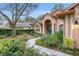 Charming home exterior featuring a welcoming arched entryway and well-manicured front garden at 19586 Sw 84Th Pl, Dunnellon, FL 34432