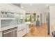 Well-lit kitchen featuring white cabinets, stainless steel appliances, and a farmhouse sink beneath a window at 19586 Sw 84Th Pl, Dunnellon, FL 34432