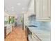 Bright kitchen features white cabinetry, stainless steel appliances, and a breakfast nook with large windows at 19586 Sw 84Th Pl, Dunnellon, FL 34432