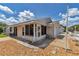 Home exterior with a patio area and rock landscaping with a white picket fence at 2608 Botello Ave, The Villages, FL 32162