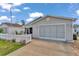 Lovely one-story home with a gray exterior, complemented by a well-kept lawn and a paved driveway at 2608 Botello Ave, The Villages, FL 32162