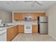 Traditional kitchen includes light wood cabinetry, stainless steel appliances, and laminate flooring at 2608 Botello Ave, The Villages, FL 32162